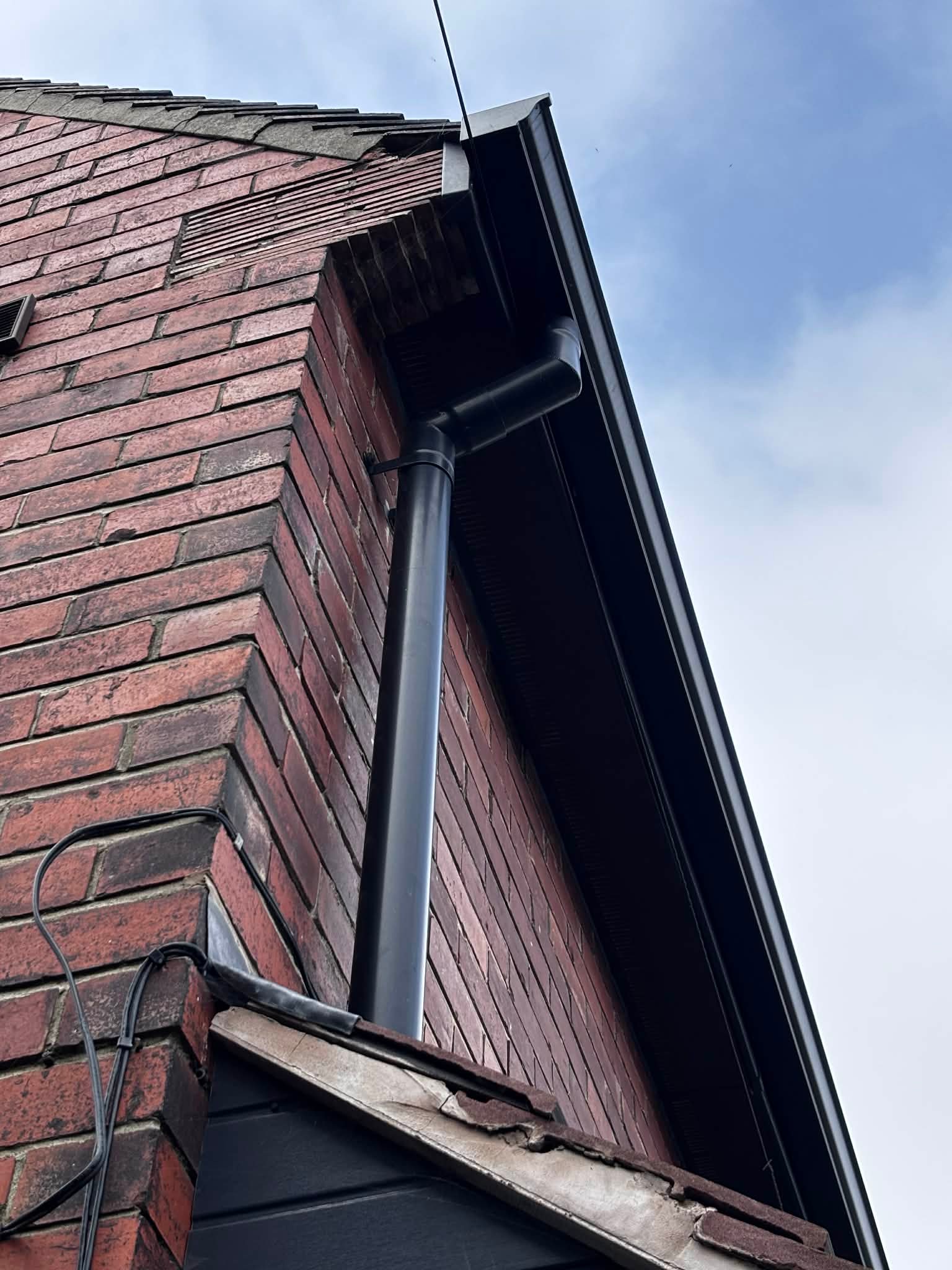 Finished gutter and downpipe detail on building