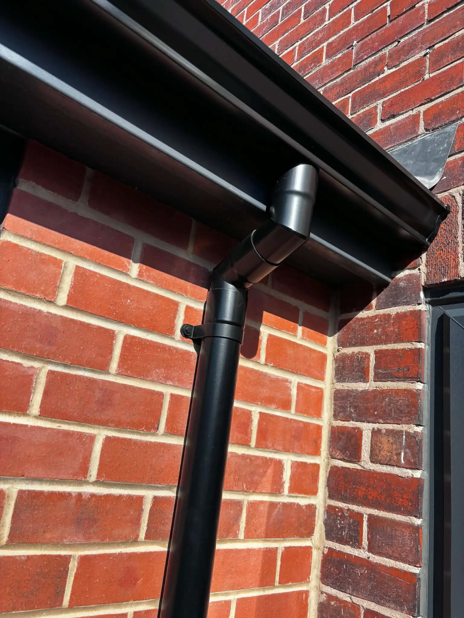 Close-up of gutter outlet connected to downpipe
