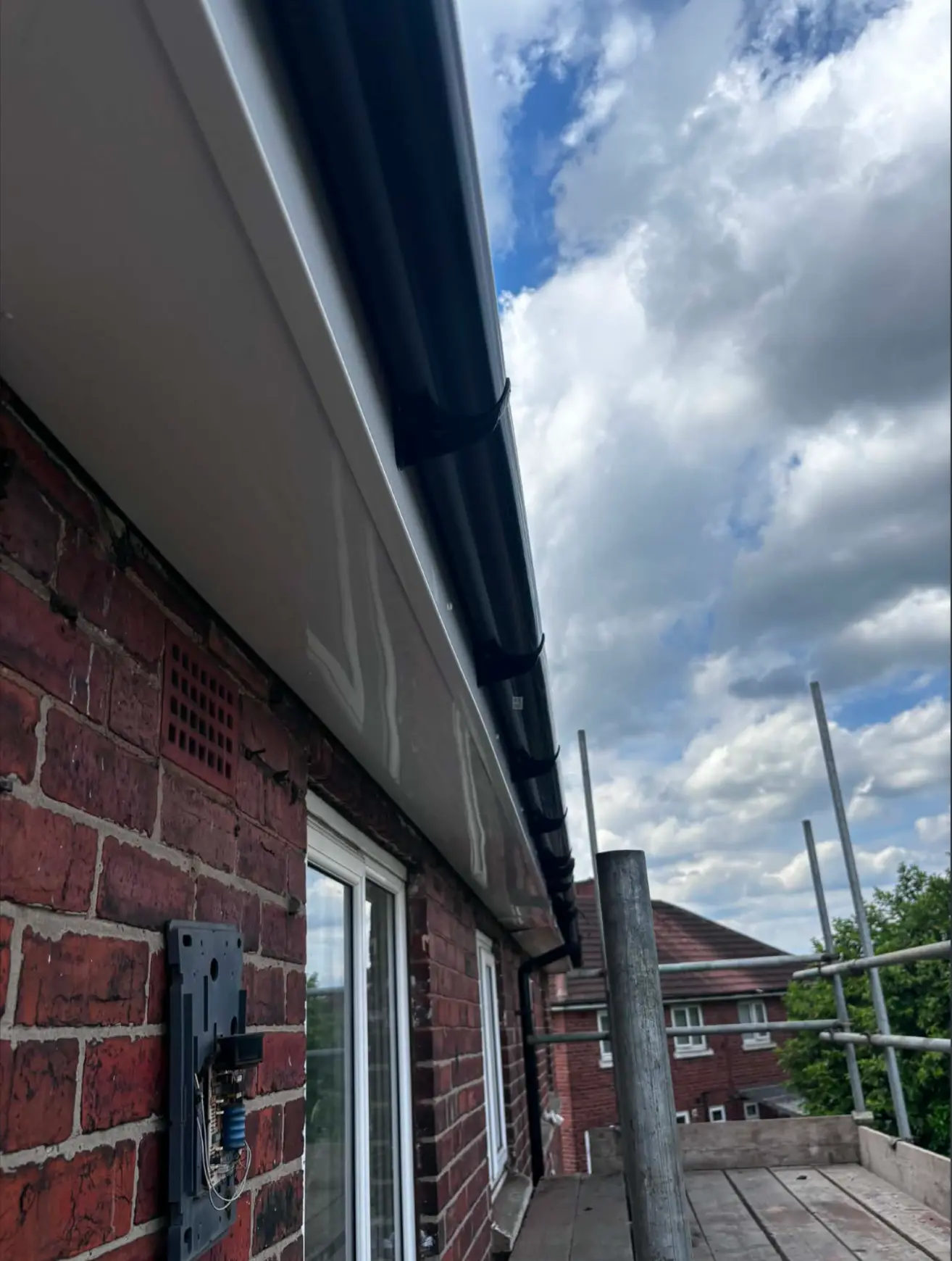 Clean white finished roofline with black guttering after installation